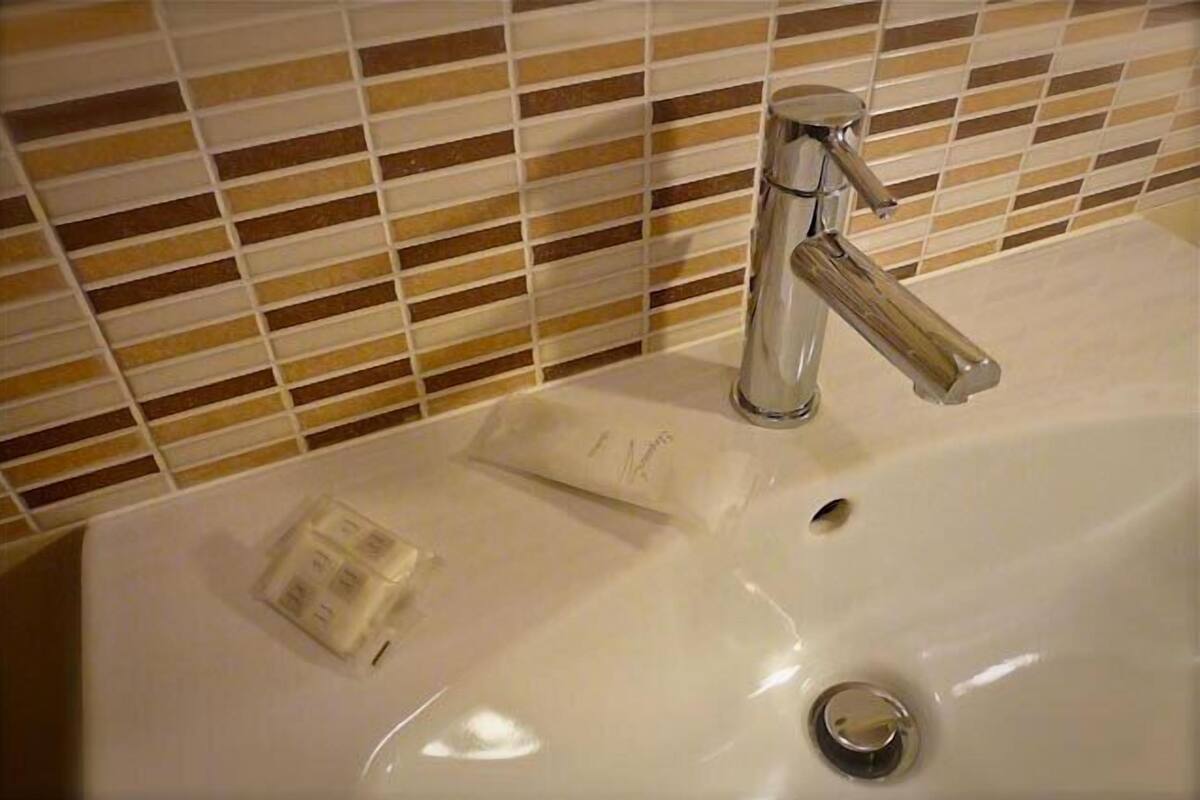 Un lavabo de salle de bain avec un robinet chromé et un distributeur de savon.