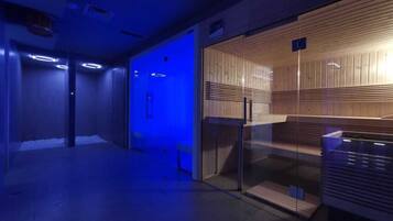 Un interno moderno con un ingresso tramite porta in vetro, una parete rivestita in legno e un corridoio illuminato di blu.