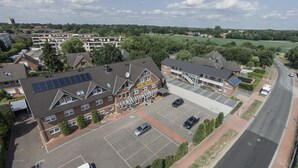 An aerial view of a residential building with a parking lot, solar panels on the roof, and a clear sky. - Hotel Globotel Business (Garbsen)