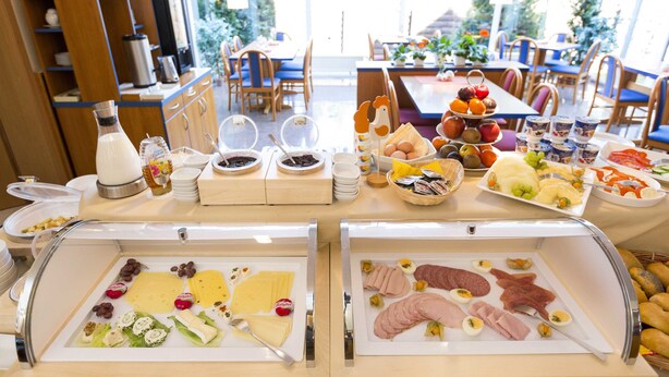A buffet with various food items including fruits, cheeses, meats, and bread. - Hotel Globotel Business (Garbsen)