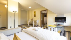 A hotel room with a bed, a desk with a TV, a chair, and a small table. - Hotel Globotel Business (Garbsen)