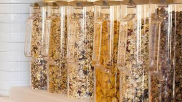 Una hilera de recipientes transparentes con diversos cereales y semillas.