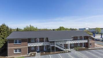 A two-story building with a covered walkway and a parking lot.