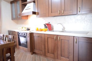 Una cocina con armarios de madera, una estufa y un lavabo.