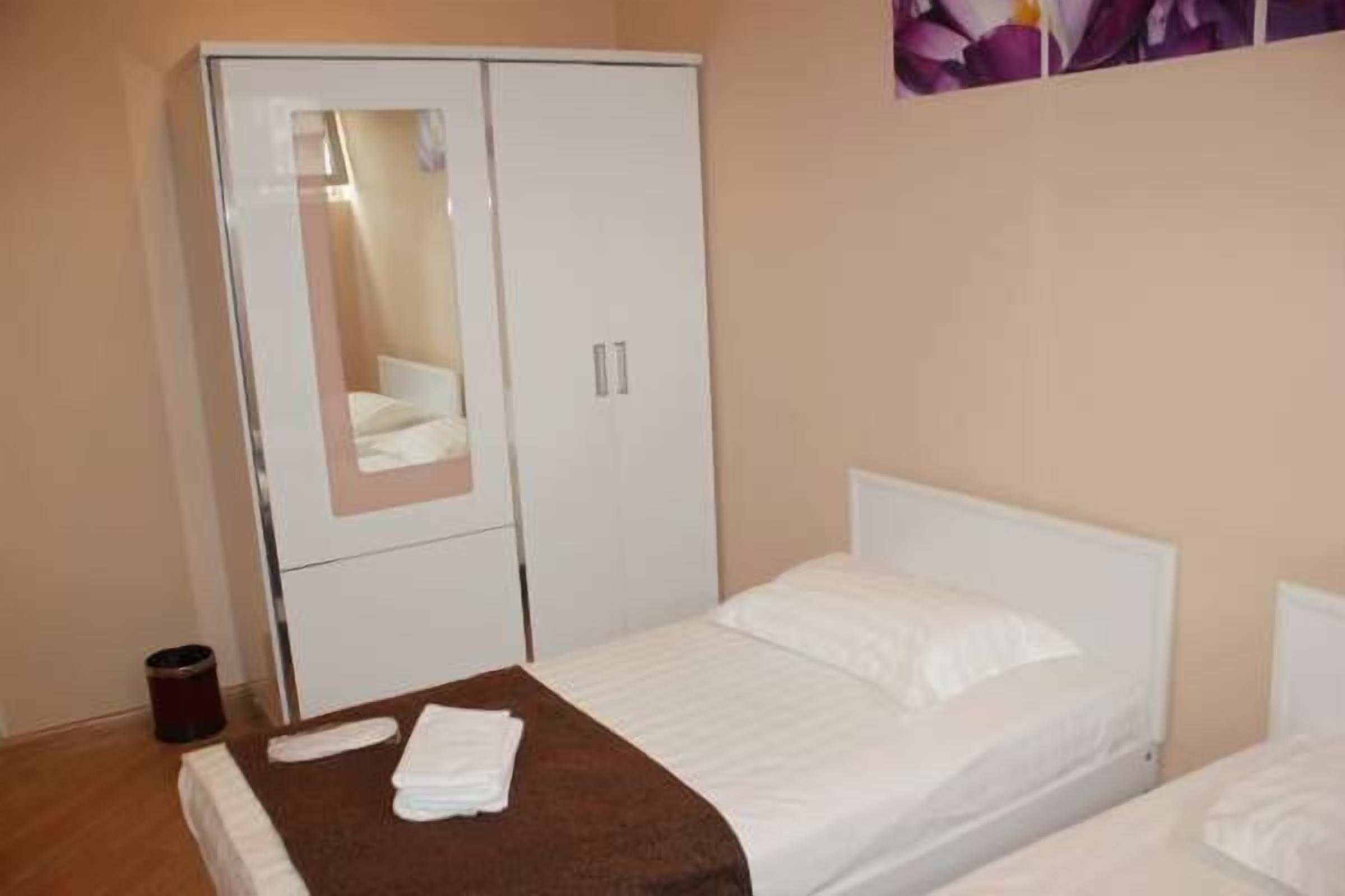 Ein Schlafzimmer mit einem Bett, einem Kleiderschrank und einer kleinen Mülleimer.