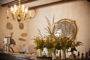 Ein Zimmer mit einer Chandelüster, einem Spiegel und mehreren Vasen mit Trockenpflanzen.