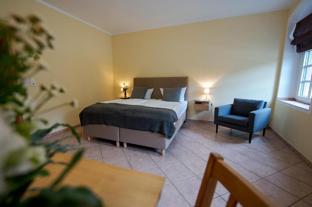 A bedroom with a bed, bedside tables, a chair, and a window.