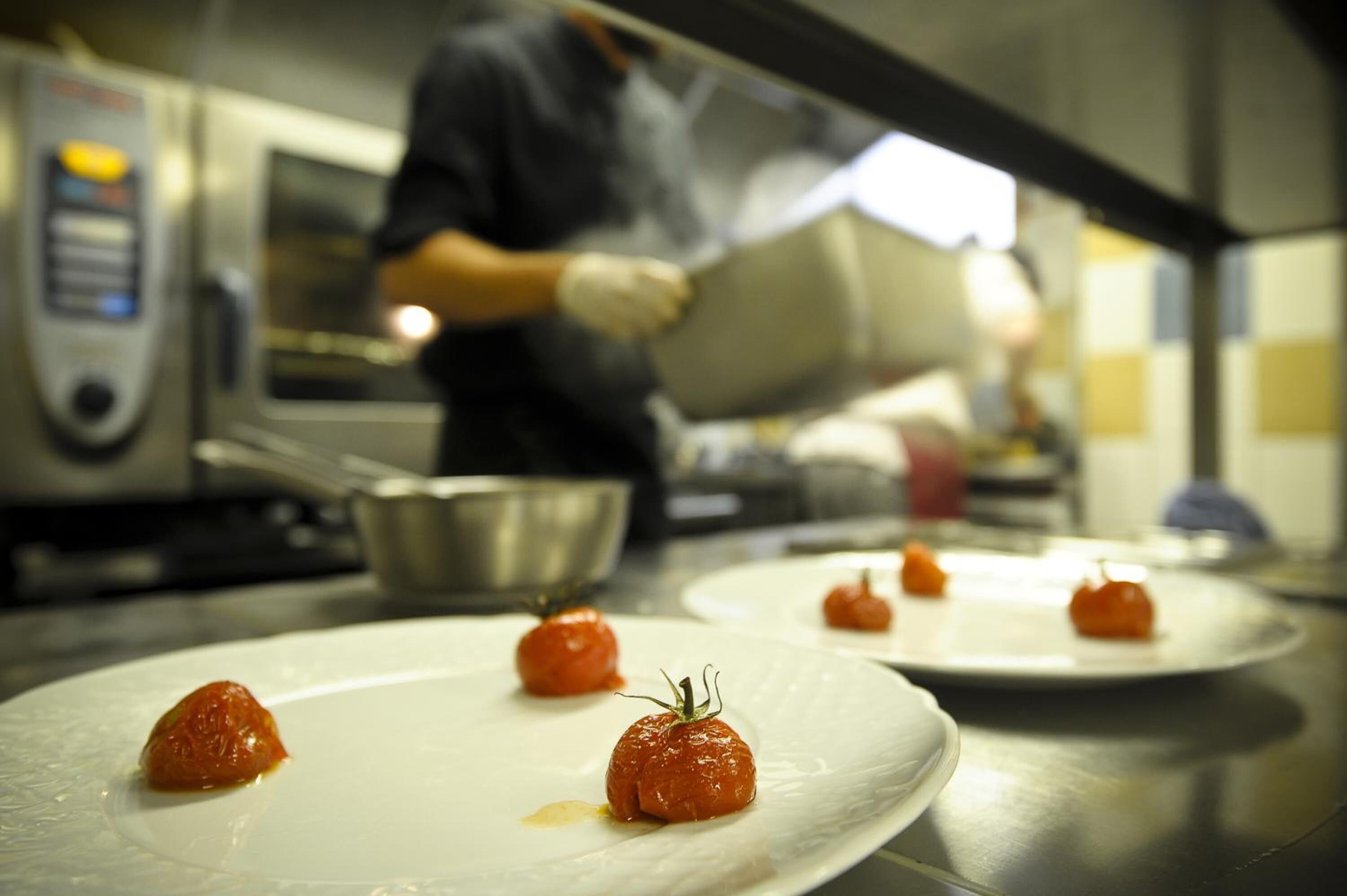 A kitchen with plates of food and a person in the background.