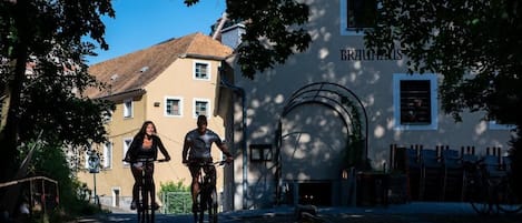 A building with a sign 'BRAUHAUS' and a bicycle parked in front.
