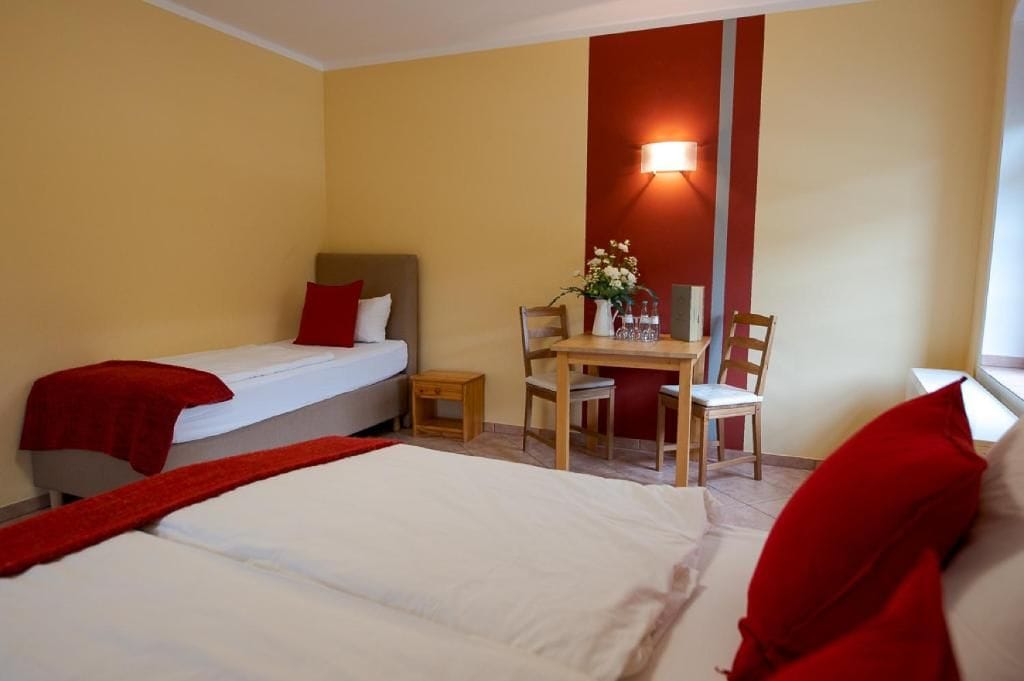 A hotel room with two beds, a desk, and a chair.