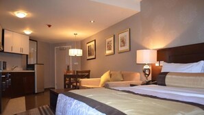 A hotel room with a large bed, a desk, and a kitchenette. - Lakewood Luxury Apartment (Abuja)