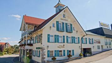 Traditional hotel with a steeply pitched roof and balcony, offering a restaurant on the ground floor.