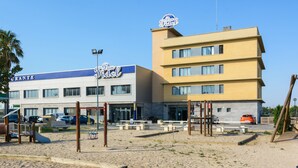 A hotel with a blue and white facade, outdoor seating area, and a playground. - Hospedium Hotel Don Fidel (Cuarte de Huerva)