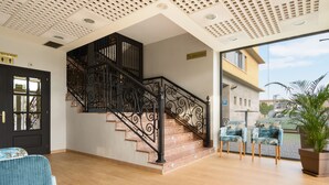 A staircase with ornate black railings, a wooden floor, and a view of the outside. - Hospedium Hotel Don Fidel (Cuarte de Huerva)