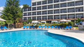 Een buitenzwembad, ligstoelen bij het zwembad