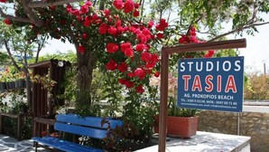 A signboard for 'STUDIOS TASIA' with contact details and a website URL. - Studios Tasia (Naxos)