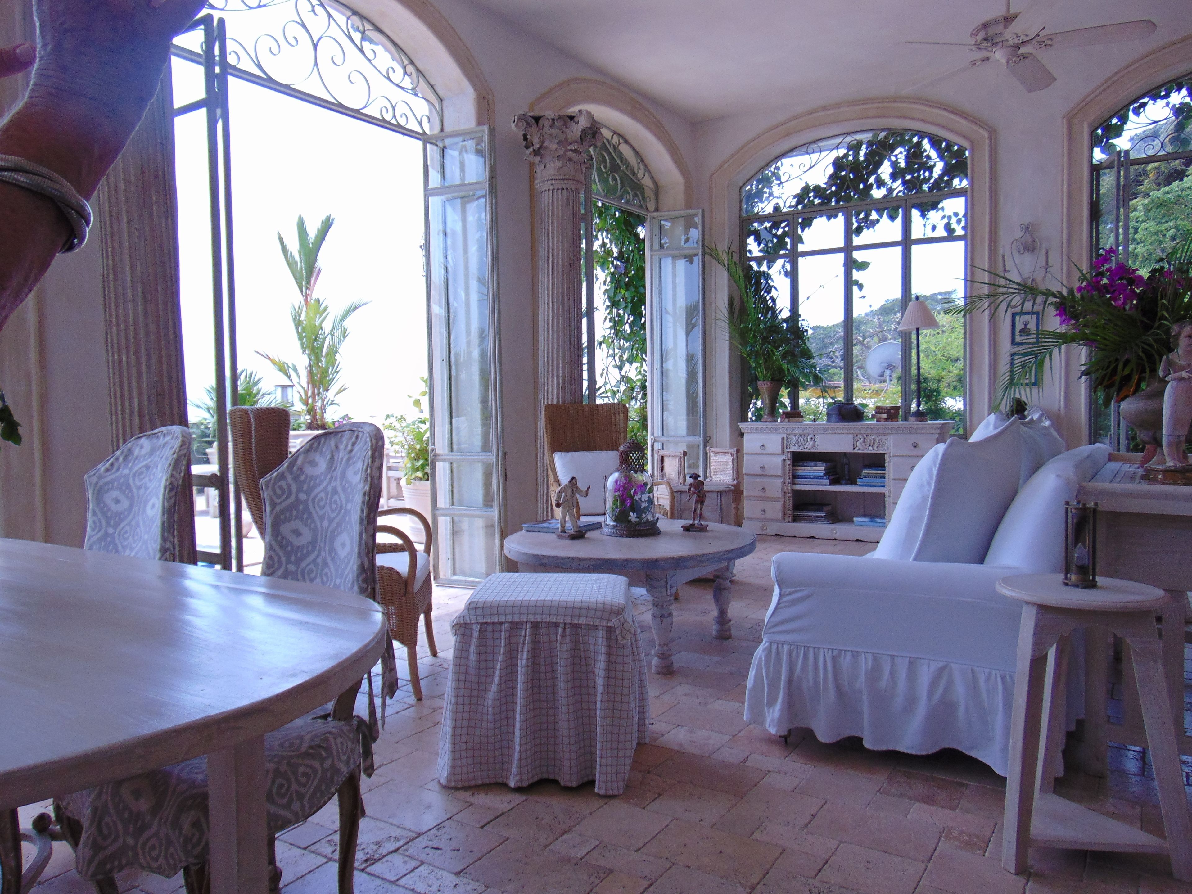 A spacious room with a large arched window, a dining table, and comfortable seating.
