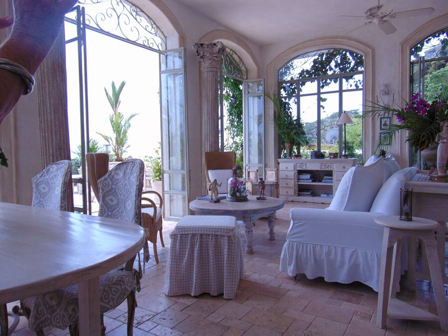 A spacious room with a large arched window, a dining table, and comfortable seating.