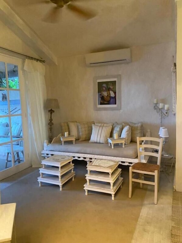 Una habitación acogedora con un sofá, una silla y una mesa llena de libros.