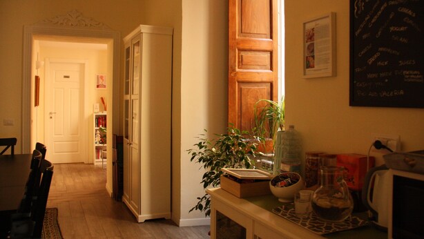 A kitchen with a wooden cabinet, a water dispenser, and a chalkboard menu. - Il Conservatorio B&B (Naples)