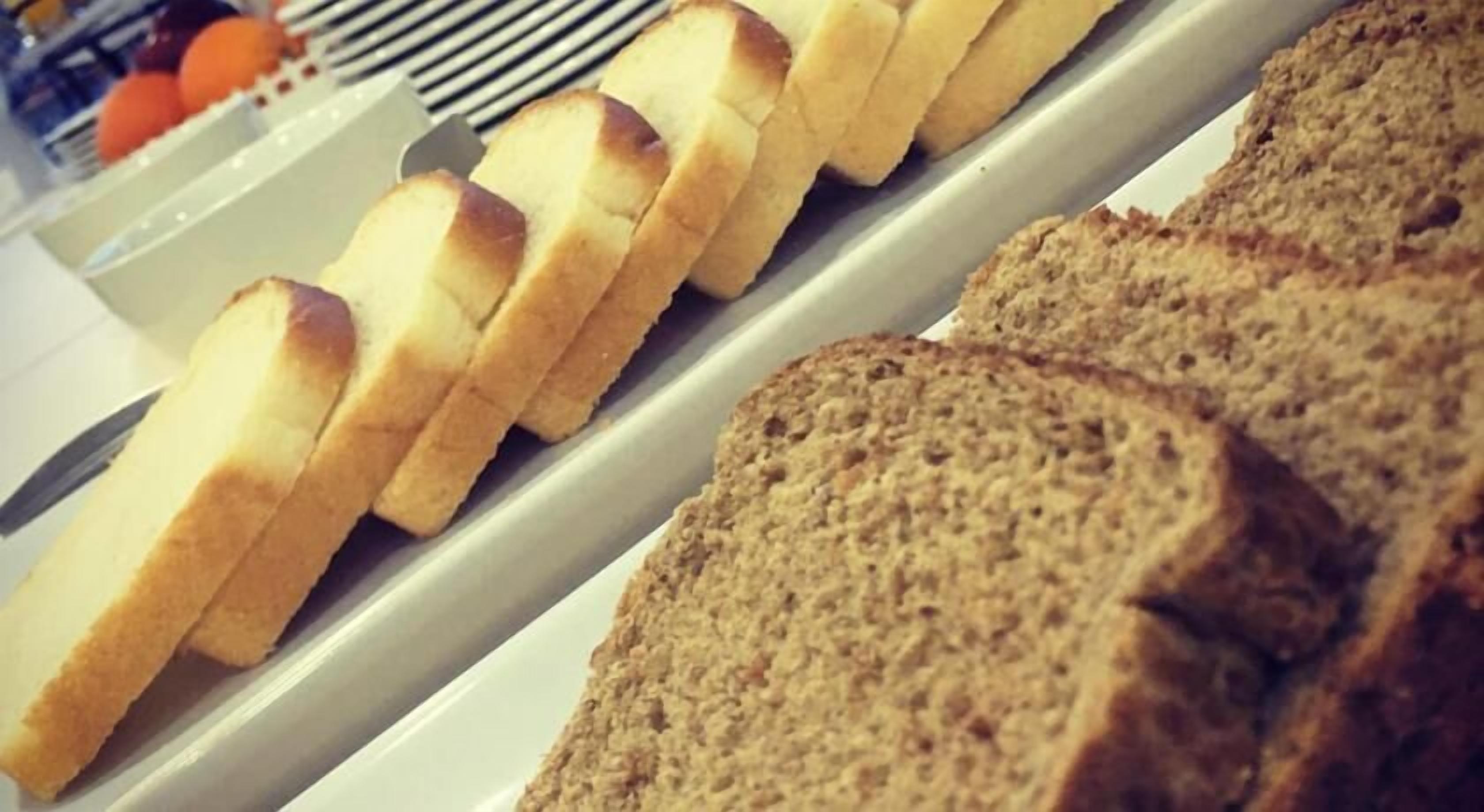 Een presentatie van sneetjes brood en broodjes in een bakkerij.