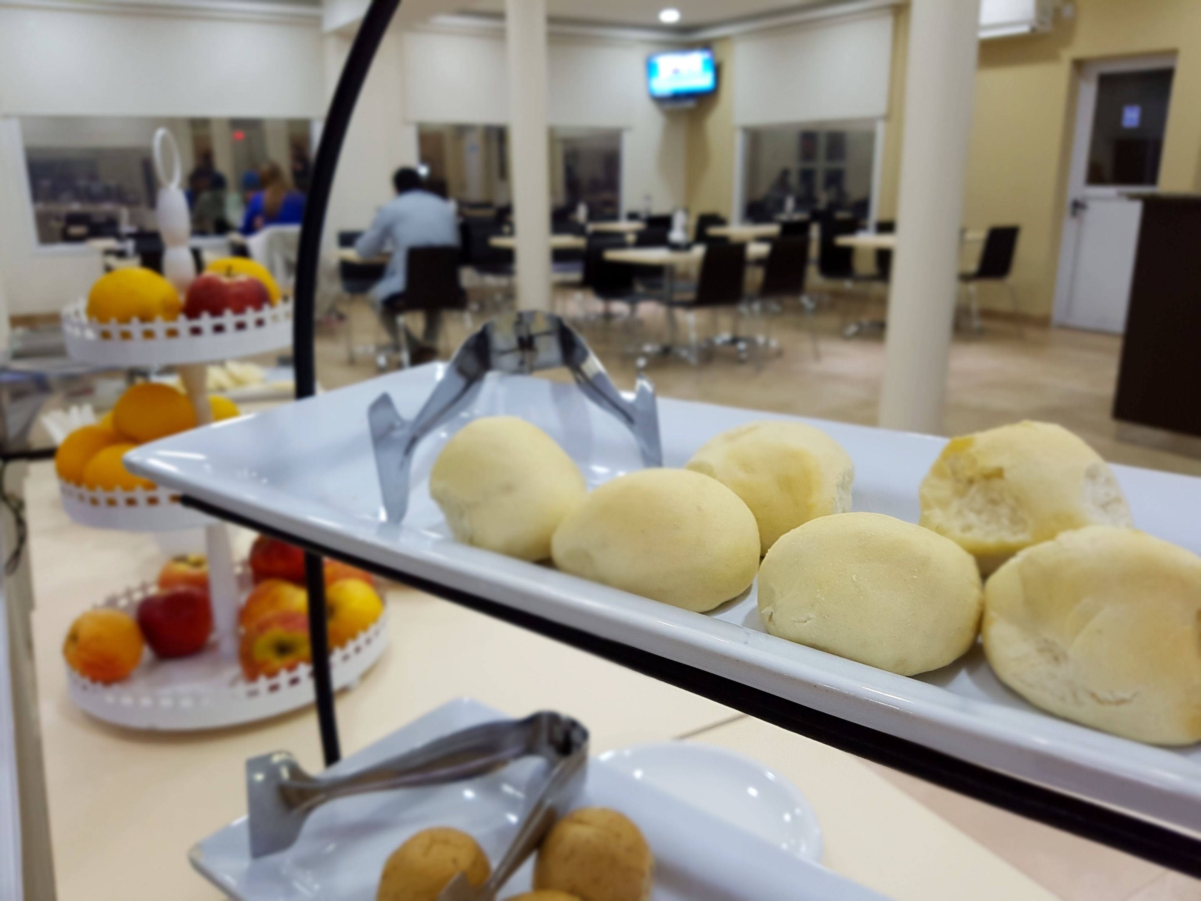 A buffet with various food items including fruits and bread rolls.
