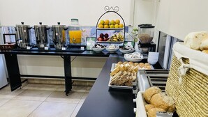 A buffet setup with various food items and beverages. - Departamentos Campitelli (General Pacheco)