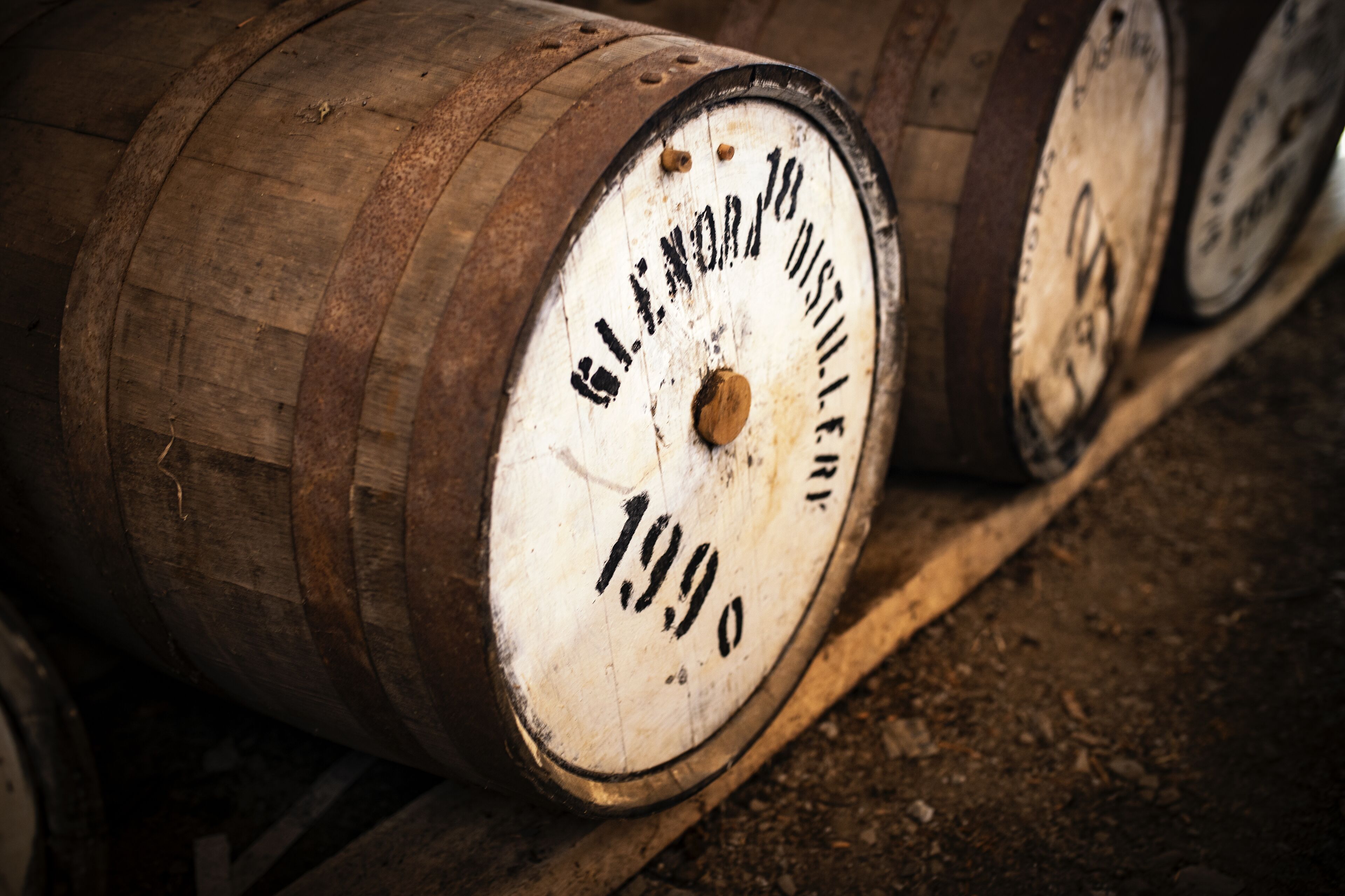 Wooden barrels with labels, likely used for aging or storing liquids.