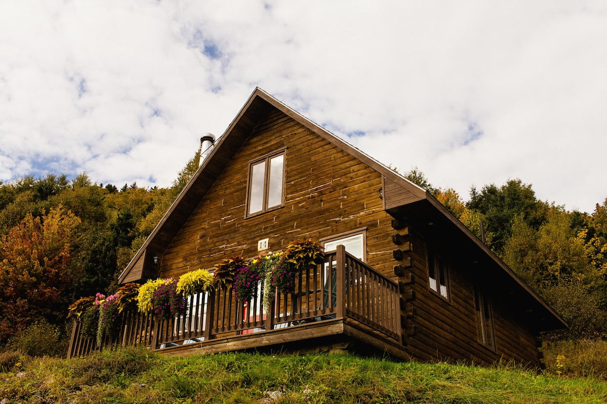 Eine Holzhütte mit Balkon, umgeben von Bäumen.