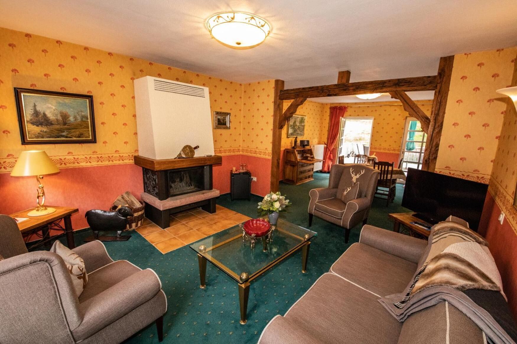A cozy living room with a fireplace, comfortable seating, and a television.