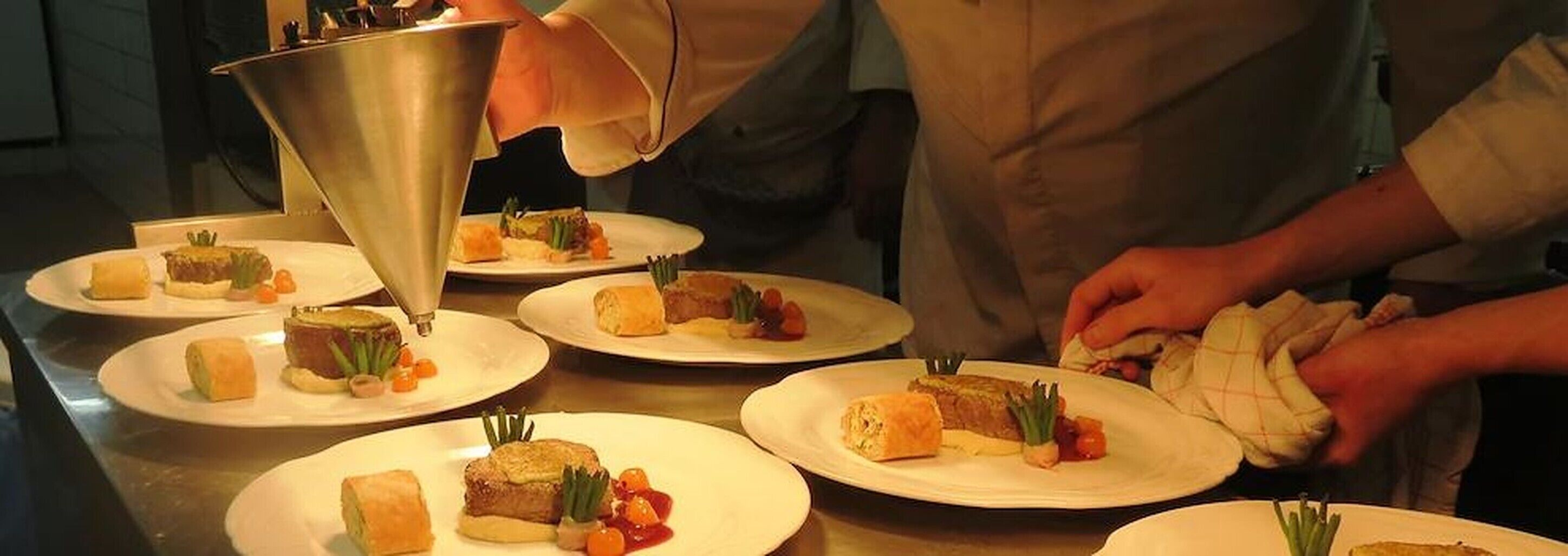 Un chef preparando platos, destacando la presentación de los alimentos.
