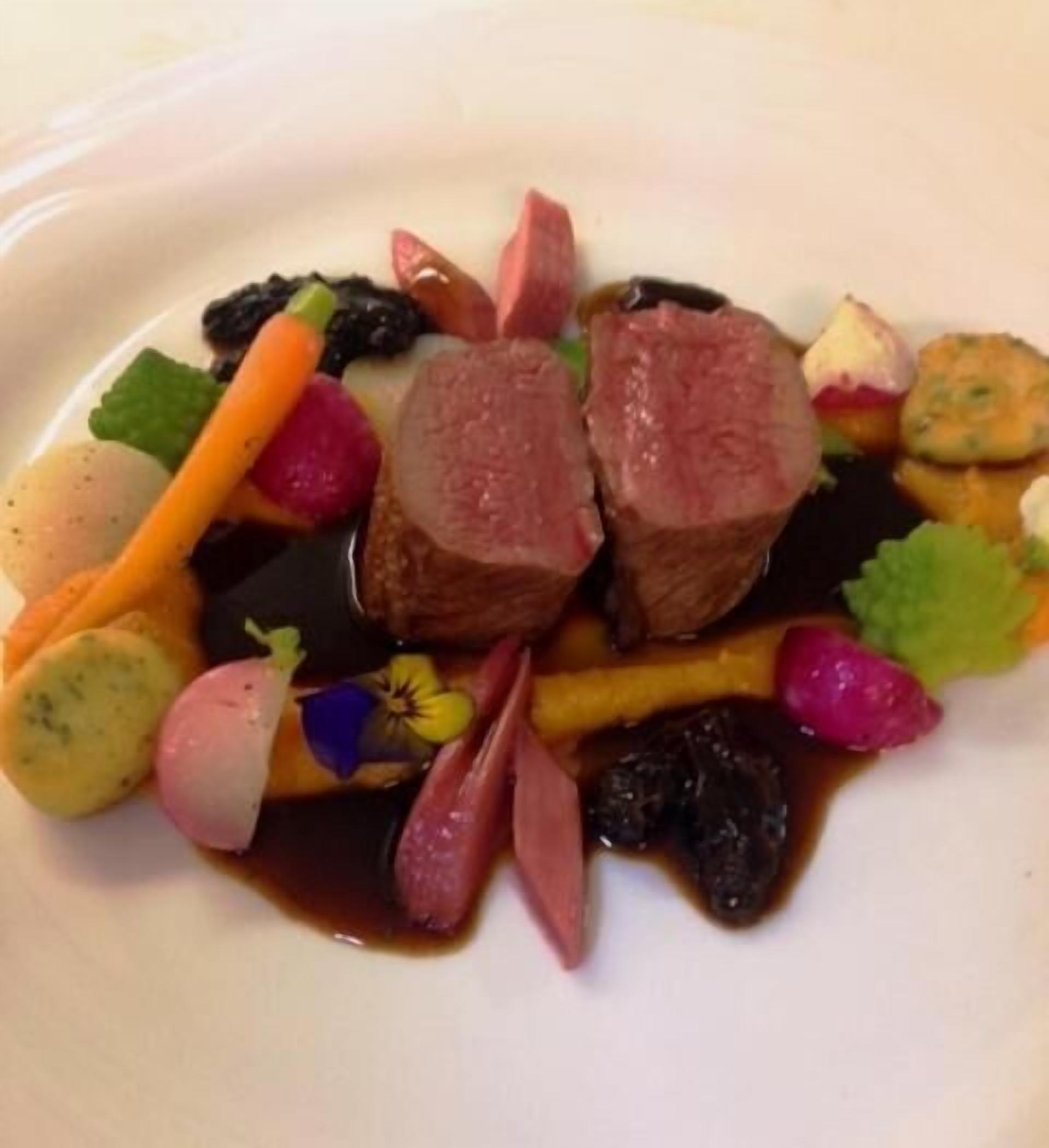 A plate of food with various vegetables and a piece of meat.