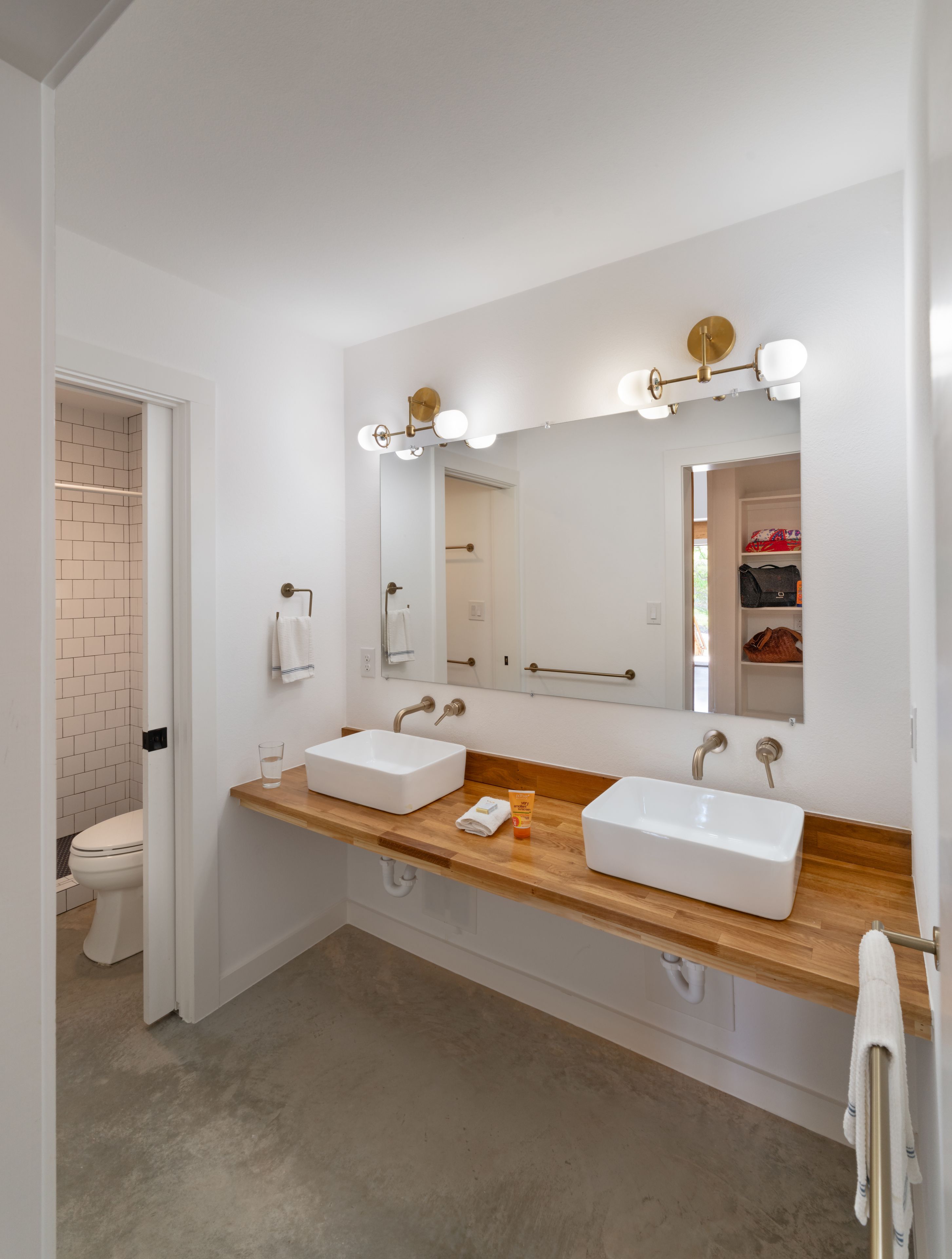Une salle de bain moderne avec deux vasques, un grand miroir et une douche à l’italienne.