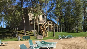A beach area with green lounge chairs and a wooden staircase leading to a building. - Kavanaugh's Sylvan Lake Resort (Brainerd)