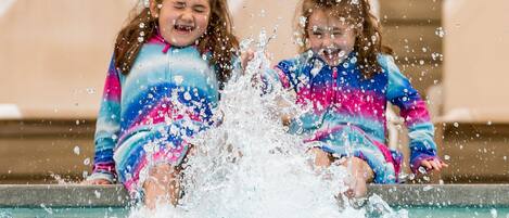 Zwei Kinder planschen im Schwimmbecken.