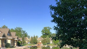 A tranquil residential area with a clear pond reflecting the houses and trees. - Kavanaugh's Sylvan Lake Resort (Brainerd)
