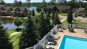A resort with a swimming pool, lounge chairs, and a view of a lake. - Kavanaugh's Sylvan Lake Resort (Brainerd)