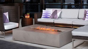 A modern outdoor seating area with wicker furniture and a concrete fire feature. - Embassy Suites by Hilton Amarillo Downtown (Amarillo)