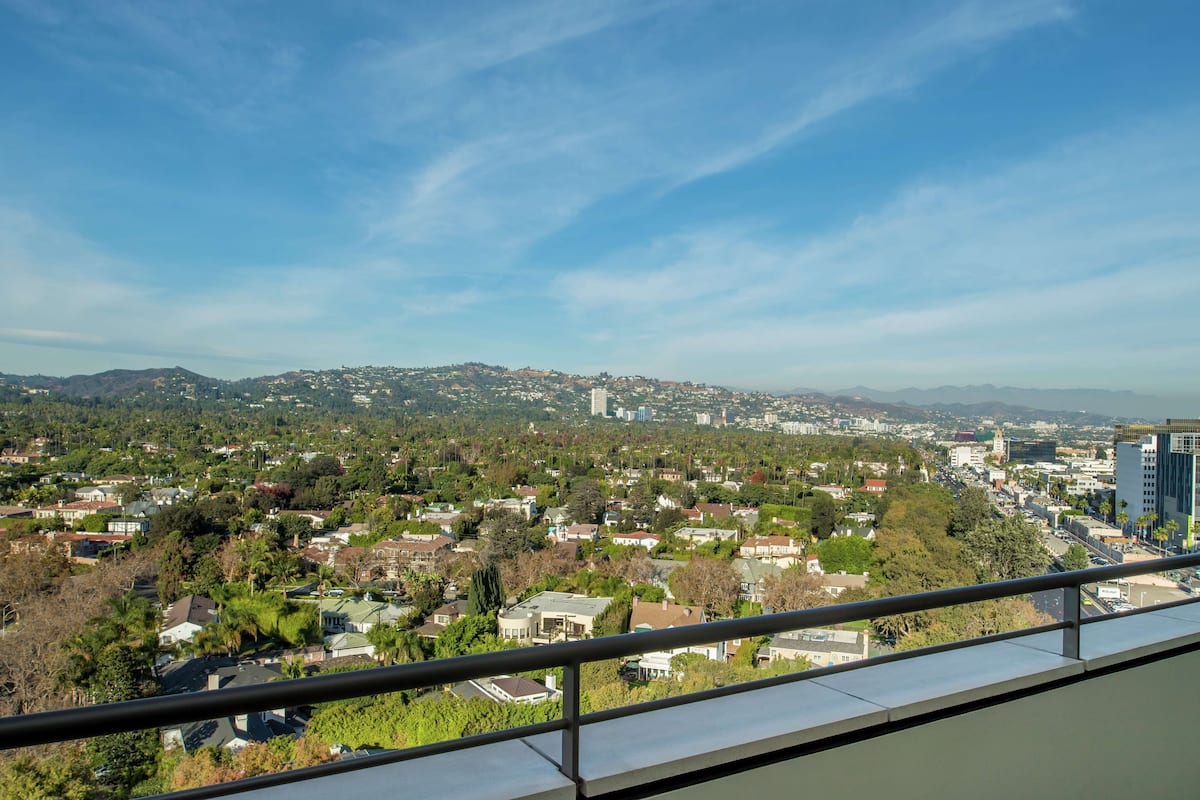 Un quartier résidentiel avec des maisons, des arbres et, au loin, une chaîne de montagnes.
