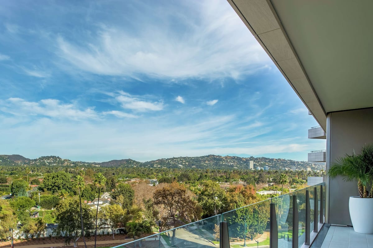 Un balcon offrant une vue dégagée sur le paysage urbain, avec les collines et les bâtiments en toile de fond.