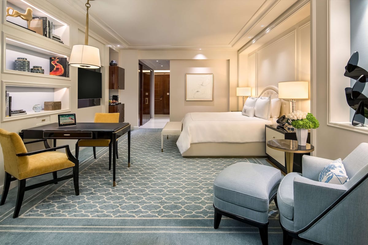 Une chambre d’hôtel équipée d’un lit, d’un bureau, d’une chaise, d’une télévision et d’une bibliothèque.