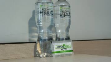 Two bottles of e-pura water and a small item with the Lemongreen Hotel logo.