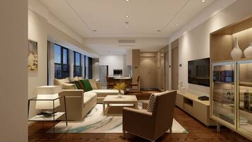 A modern living room with a sofa, armchairs, a coffee table, and a TV.