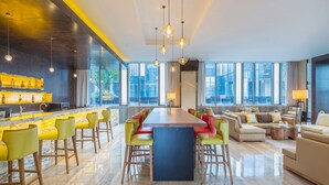 A modern hotel lobby with a long bar, seating area, and large windows offering city views. - Hilton Garden Inn Ningbo (Ningbo)