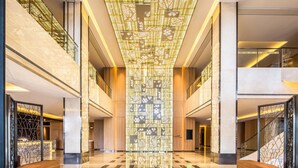 A spacious lobby with a high ceiling, a central decorative light fixture, and a checkered floor pattern. - Hilton Garden Inn Ningbo (Ningbo)