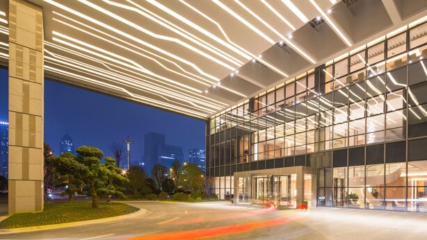 A modern building with a glass facade and a unique ceiling design. - Hilton Garden Inn Ningbo (Ningbo)