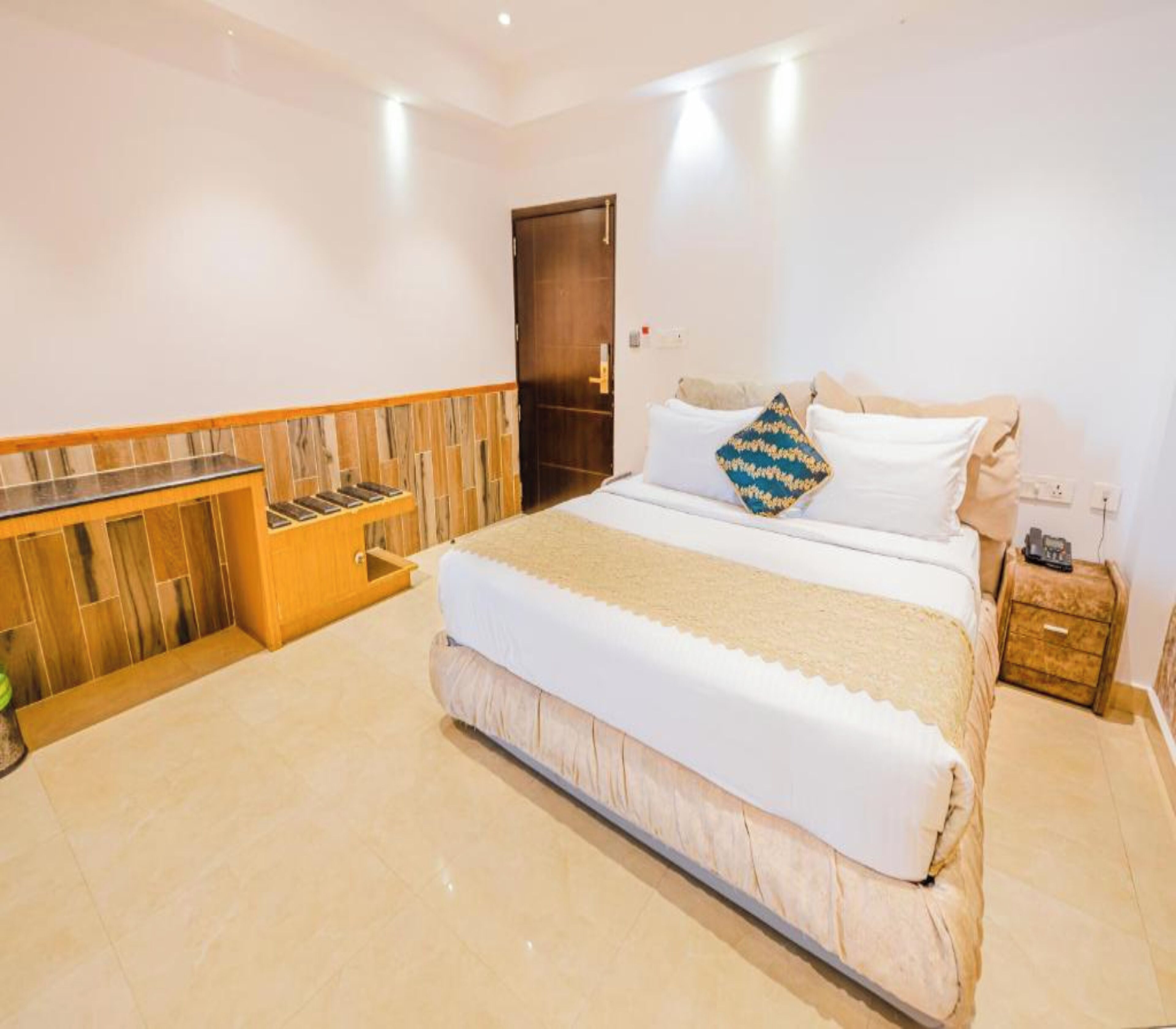 Una habitación de hotel con una cama grande, un armario de madera y una puerta.