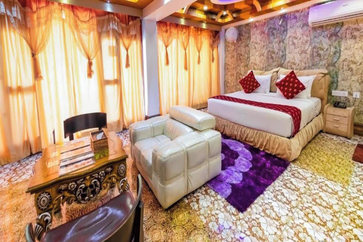A hotel room with a bed, a desk, and a chair.