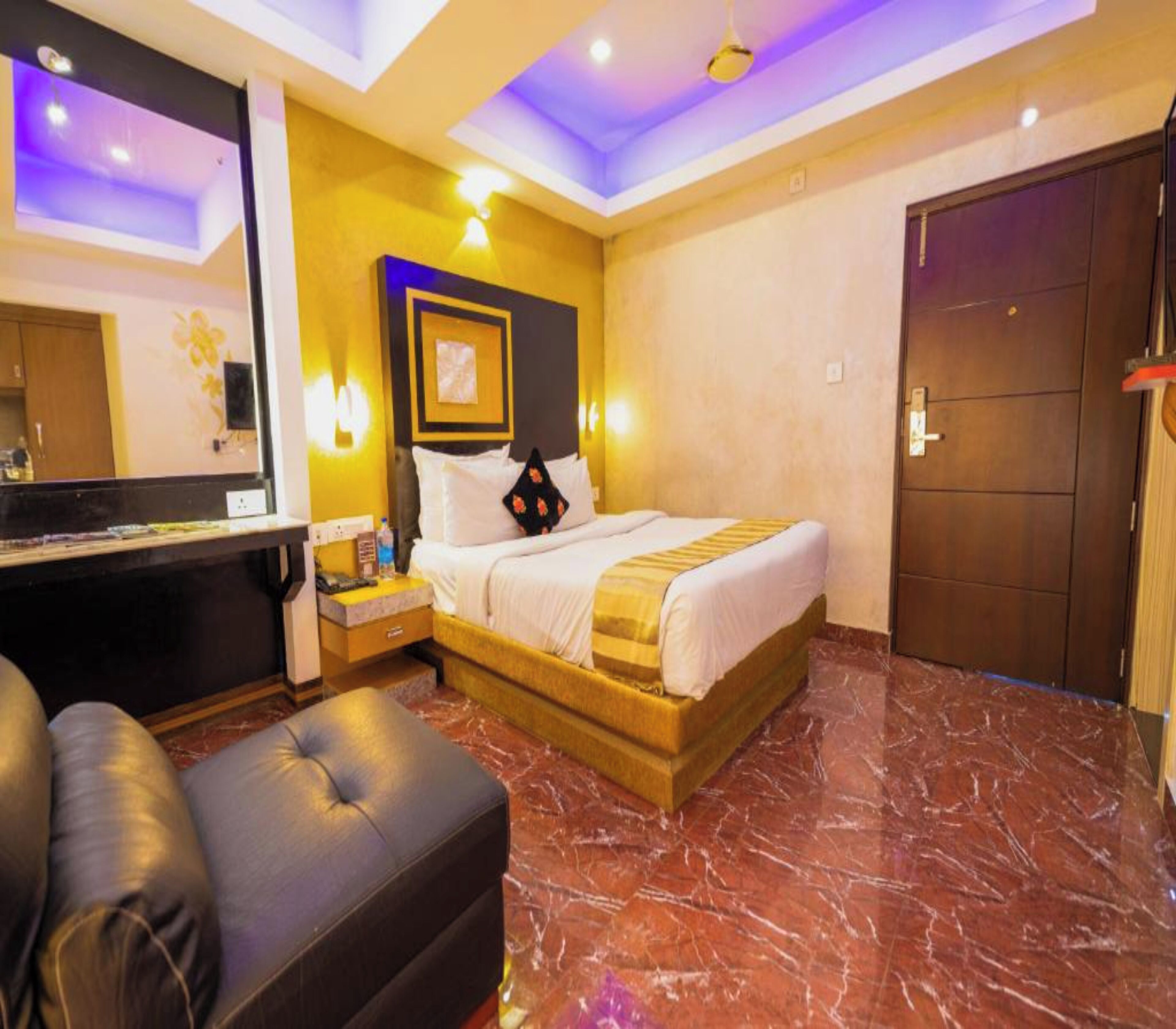 A hotel room with a bed, a desk, a chair, and a wardrobe.