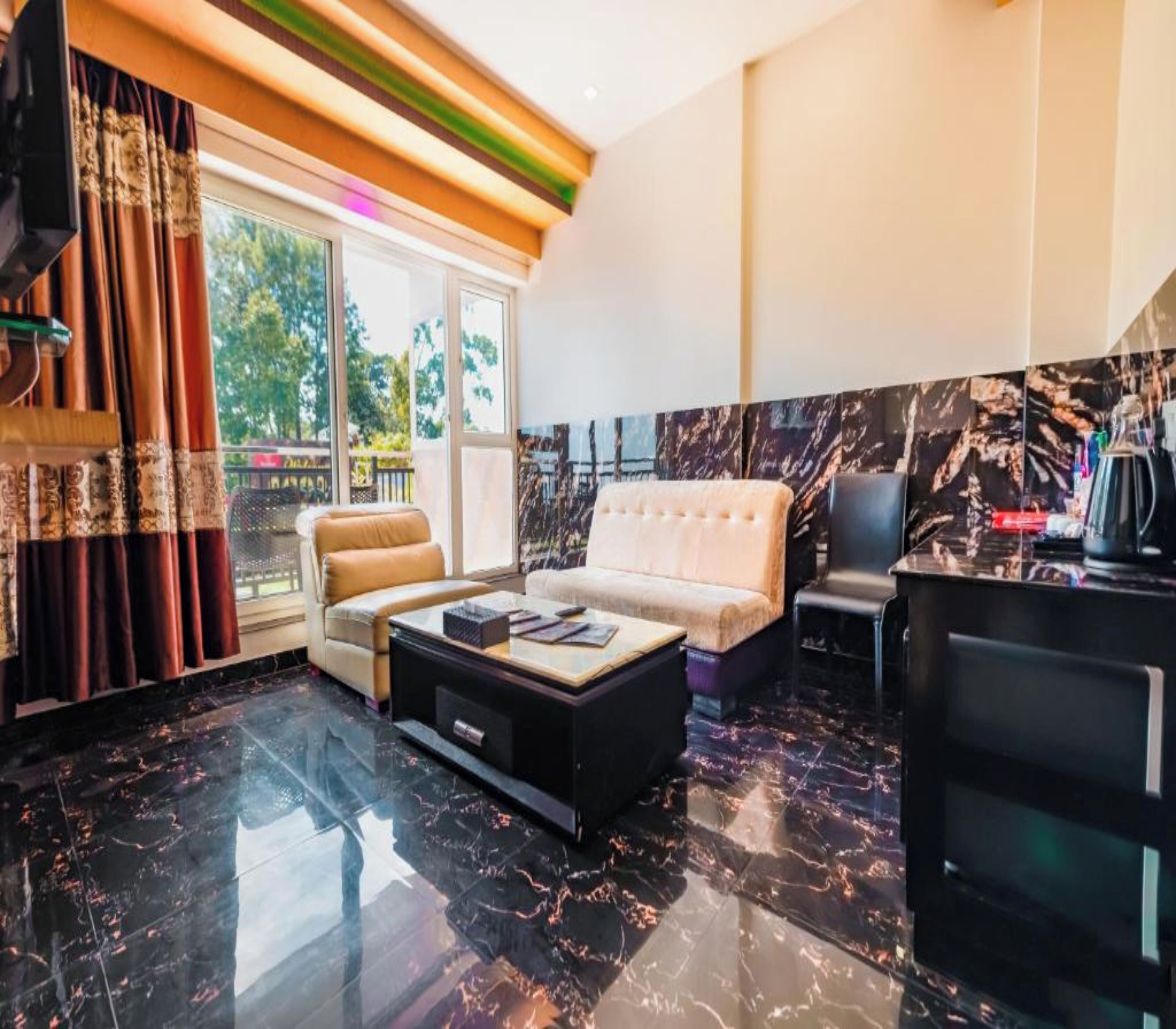 A modern living room with a sofa, coffee table, and a kitchen area with a marble backsplash.